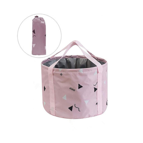 Pink collapsible storage basket with geometric patterns, shown open with handles and folded compactly in the inset image. Pink collapsible storage basket with geometric patterns, shown open with handles and folded compactly in the inset image.