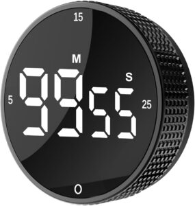 A black digital kitchen timer with white LED display showing 99 minutes and 55 seconds. The device has a textured side grip and labeled minute and second markers. A black digital kitchen timer with white LED display showing 99 minutes and 55 seconds. The device has a textured side grip and labeled minute and second markers.